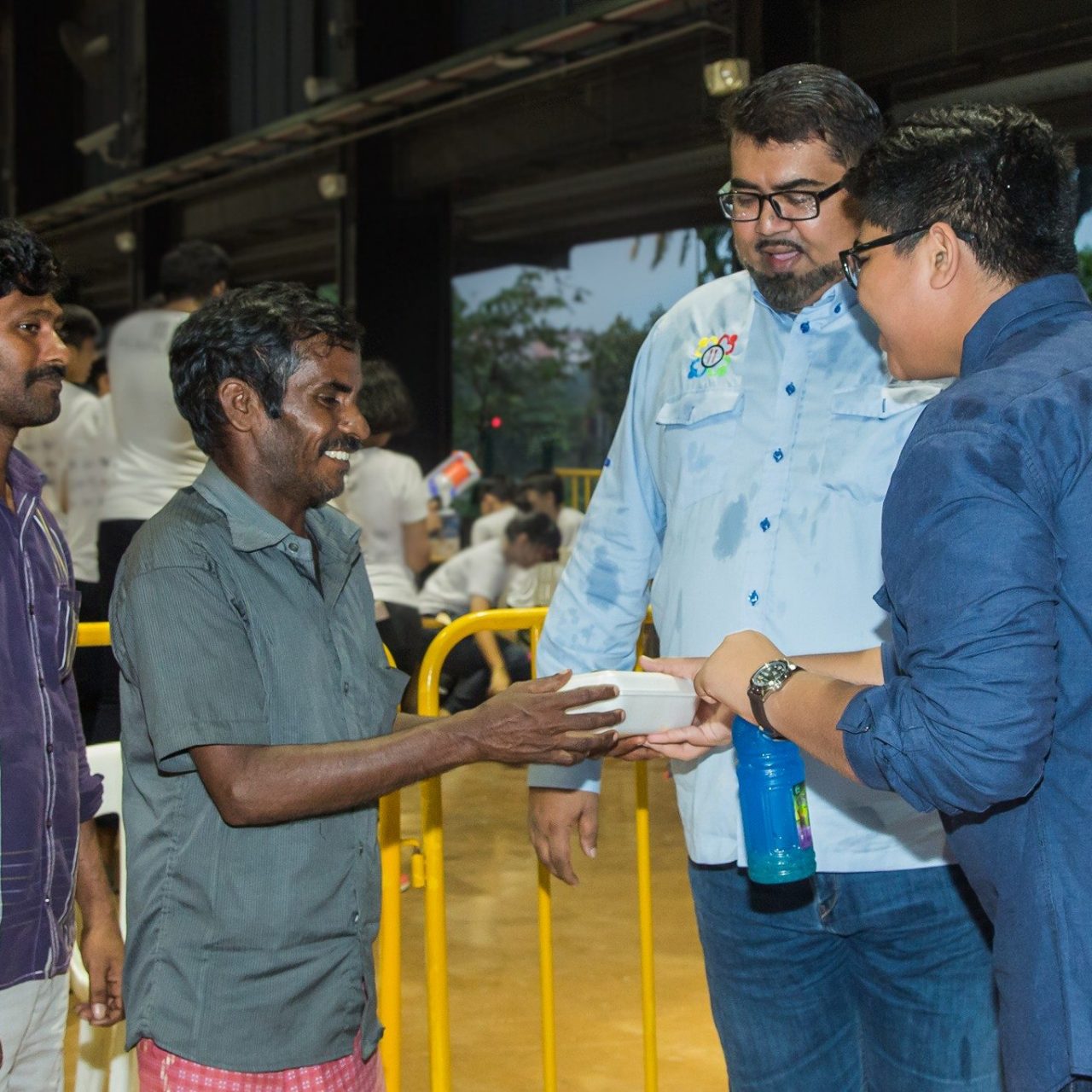 Nizar, second from right, helping to distribute food to foreign workers.
