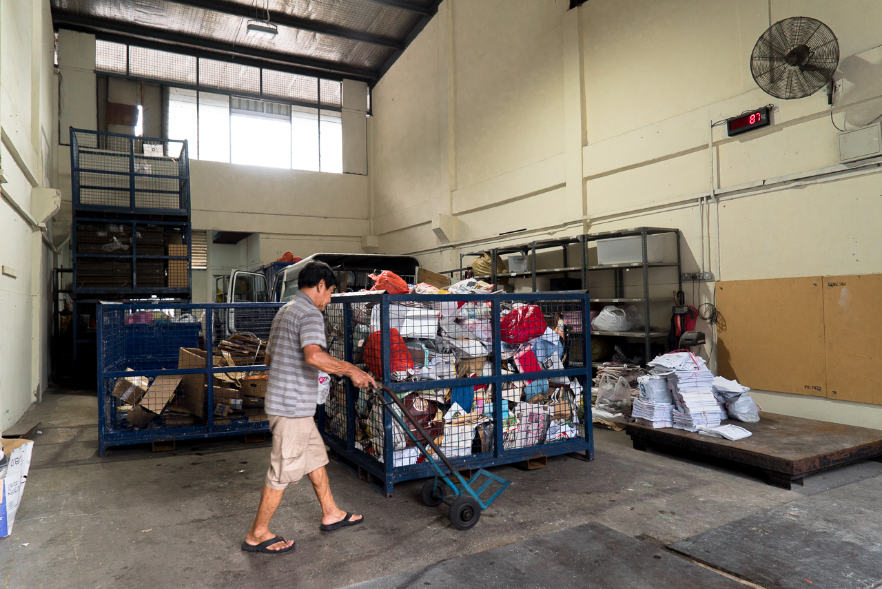 Mr Tan unloading the paper he collected.